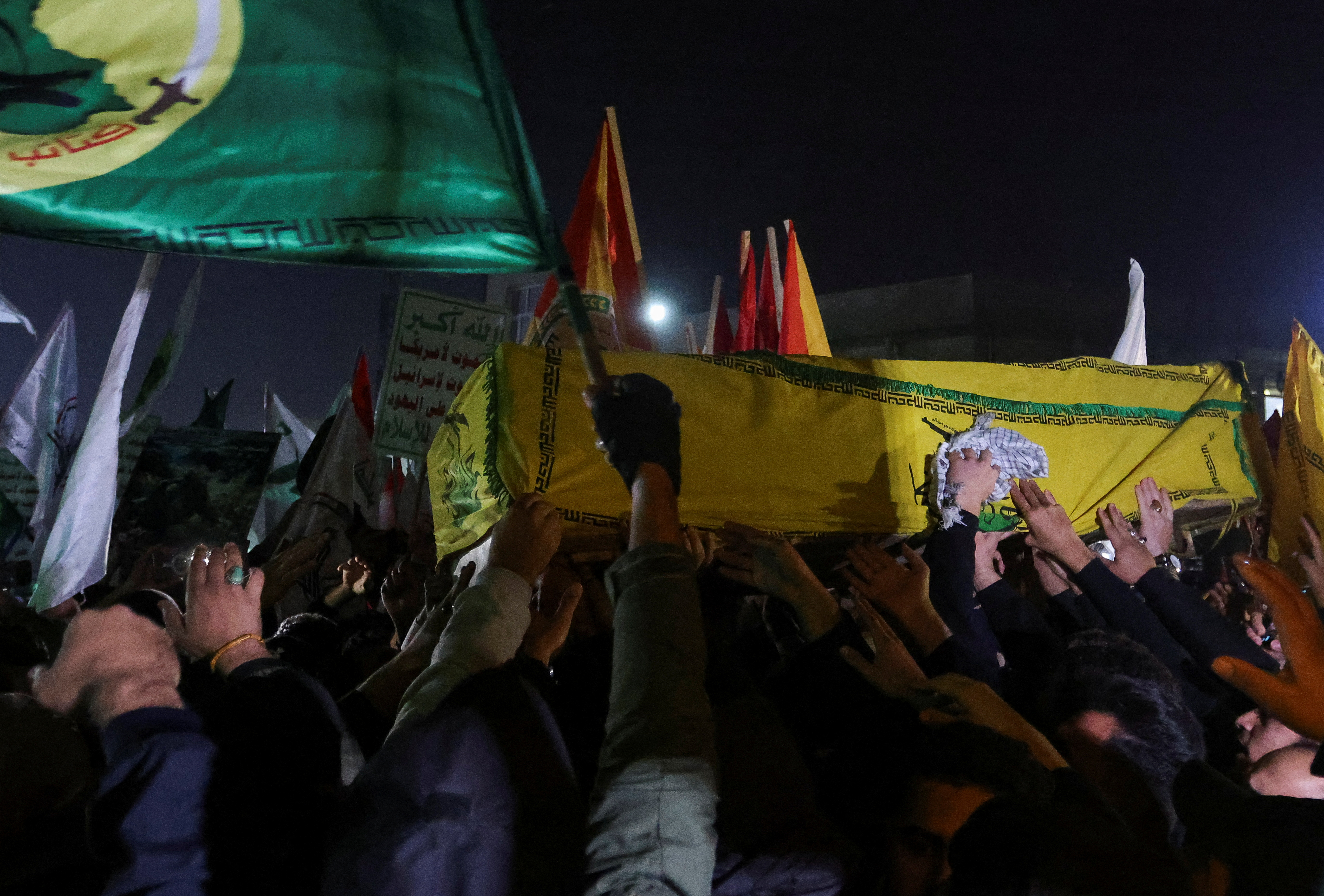 People carry the coffins of members of Harakat al-Nujaba killed by a U.S. military strike, in Baghdad