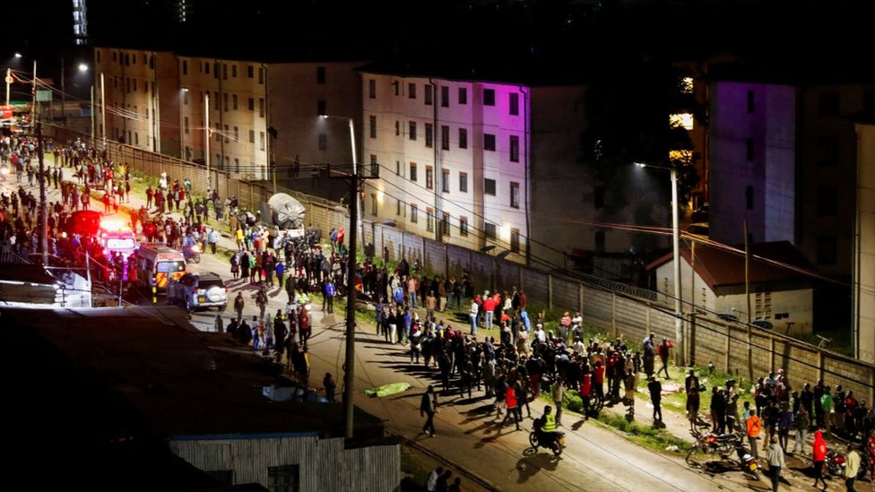 Residents gather at the scene of an explosion at a makeshift gas cylinder refilling depot in Mradi estate, Embakasi district, in Nairobi, Kenya