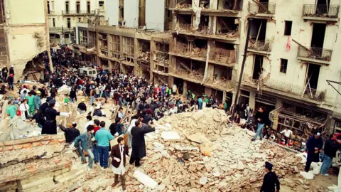 Getty Images Rescue workers sift through the rubble at the site of a car-bombing at the Asociacion Mutual Israelita Argentina (AMIA) Jewish Community Center in Buenos Aires, Argentina, on July 18, 1994